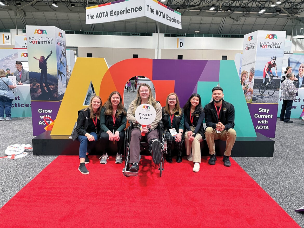 AOTA Students in front of AOTA letters